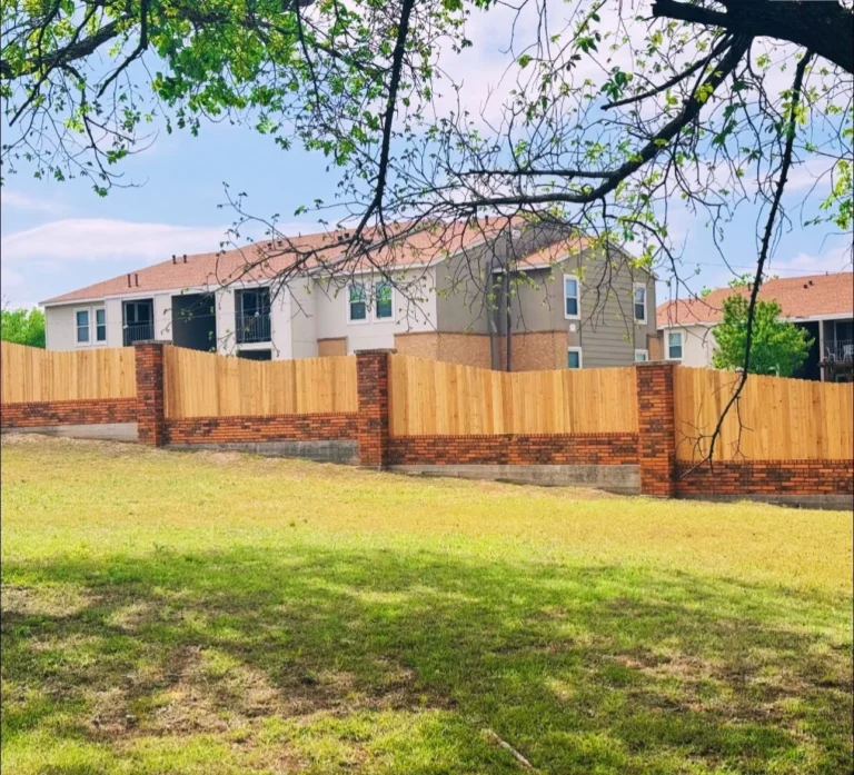 Custom wood privacy fence built with brick pillars for an HOA apartment community in Copperas Cove, TX