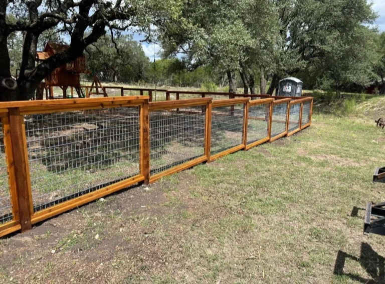 Custom split-rail wood ranch fence with wire backing for residential pet containment in Central Texas